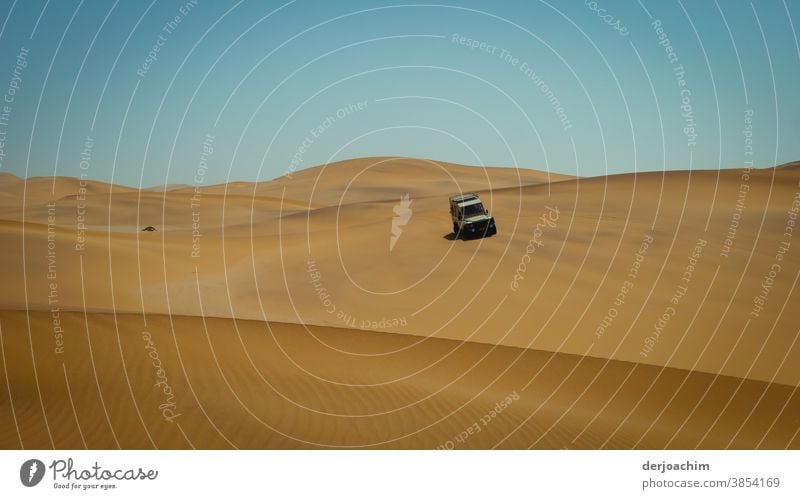 On tour in the dunes. A car drives down the sand dune. Blue sky and no clouds. Namibia Desert Africa Sand Colour photo automobile duene Landscape Nature Hot Sky