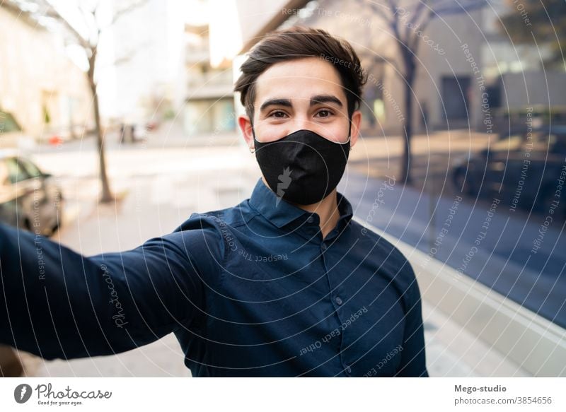 Portrait of young man taking a selfie outdoors. face mask covid-19 outside normal new lifestyle take selfie one casual wearing environment health care