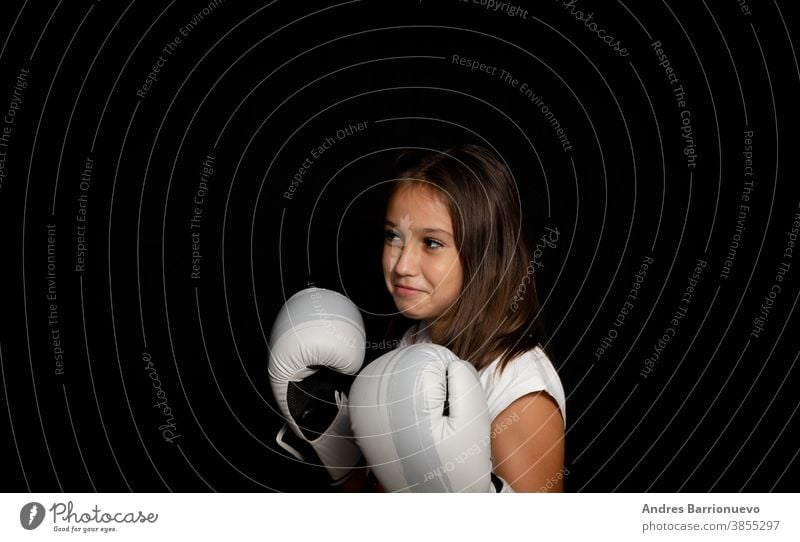 Beautiful little girl with boxing gloves posing funny on black background athletic gesticulate training fit health lady pretty wearing sportive woman female