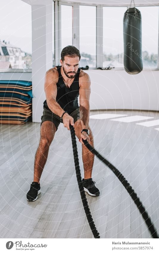 man working out with ropes in gym abdominal abs adult athlete athletic attractive male biceps body building bodybuilding caucasian chest dedication equipment