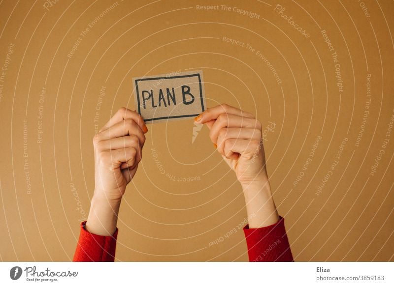 Hands hold a sign with the inscription PLAN B. Alternative life path. Plan B alternative path of life Direction solution Planning Business training