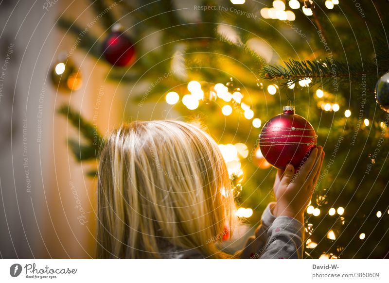 Child holds a Christmas tree ball in his hands in awe Christmas & Advent Glitter Ball reverence awed Cute Anticipation Fairy lights Illuminate