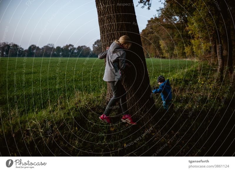 Hide-and-seek during an evening walk children Children's game Evening Dusk Exterior shot Infancy Playing Joy Colour photo Happy Happiness Cute Toddler Girl