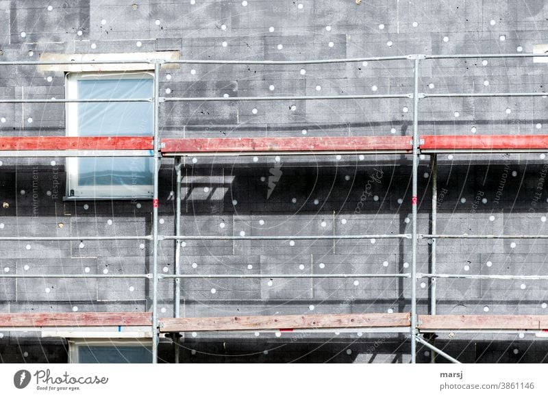 Art in building | with love for white dots on grey thermal insulation. Scaffolding with red wooden elements Sky Structures and shapes Building Facade