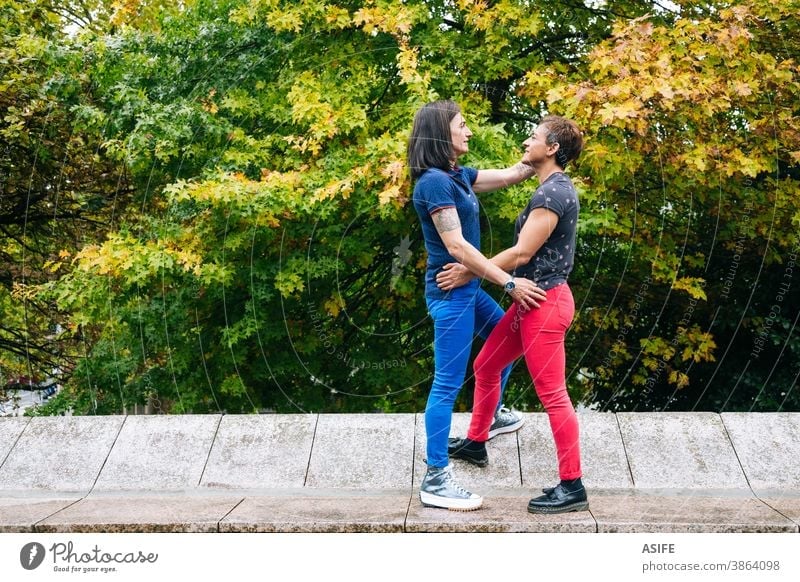 Middle aged lesbian couple enjoying together in the park LGBTQ gay middle aged 40 50 hugging holding embrace smile homosexual women real people candid love