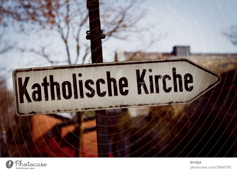 Directional road sign with the inscription " Catholic Church ". Catholic Church Catholicism celibacy Abuse somber writing Cover-up sanctimoniously Archaic