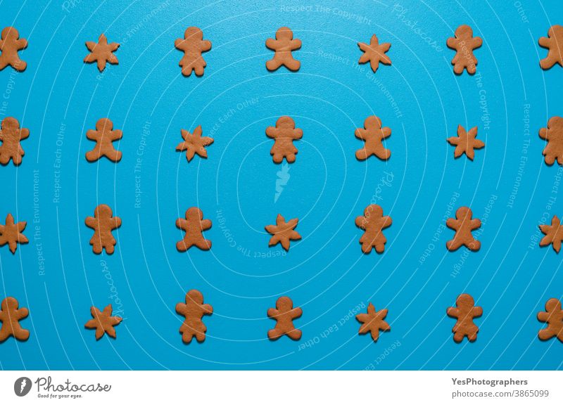 Gingerbread cookies flat lay on a blue background. Cookies arranged symmetrically on the table. above view biscuits celebration christmas cut out decoration
