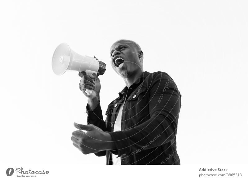 Excited black man with megaphone on white background loudspeaker shout horn announce crazy excited male ethnic african american gesture achieve scream sound