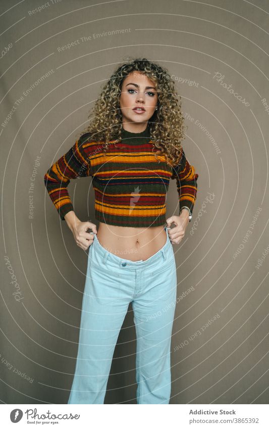 Stylish woman with curly hair in studio style studio shot cheerful apparel hairstyle delight charming appearance female smile joy relax trendy happy enjoy young