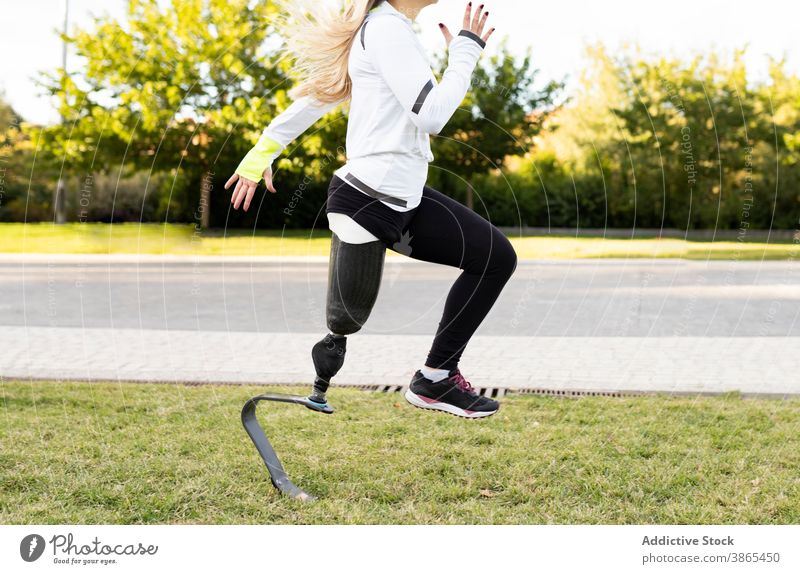 Crop runner with leg prosthesis practicing during workout paralympic woman bionic sportswoman artificial limb training exercise female practice energy