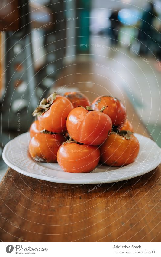 Plate with fresh persimmon fruits on  table ripe pile heap market food organic natural healthy delicious plate vitamin tasty nutrition sweet grocery raw yummy