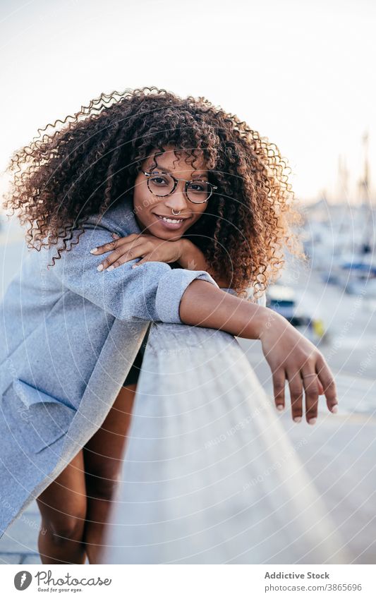 Cheerful black woman leaning on railing in port fence smile rest city style happy modern female ethnic positive african american cheerful glad young casual joy