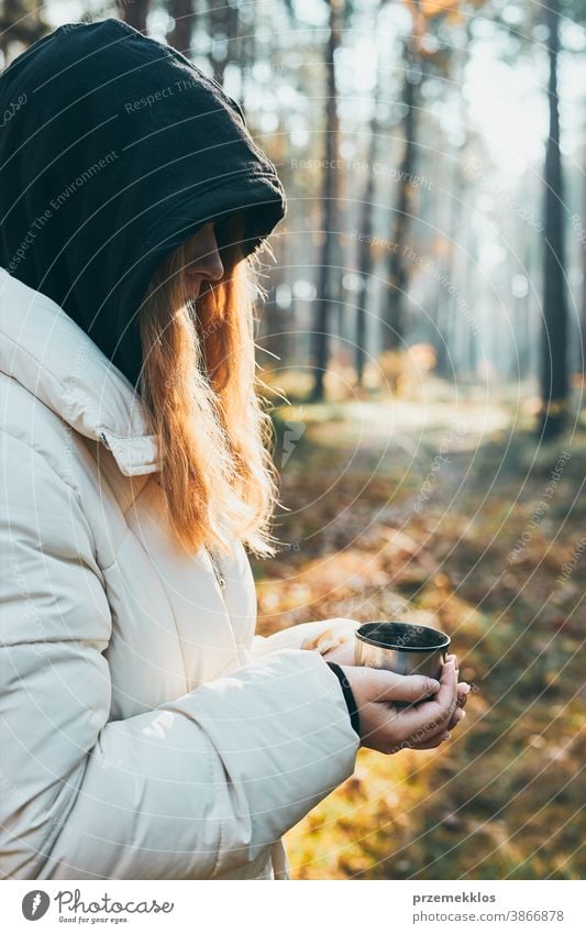 https://www.photocase.com/photos/3866878-woman-in-a-hood-having-break-during-autumn-trip-holding-cup-with-hot-drink-from-thermos-flask-on-autumn-cold-day-active-girl-wandering-in-a-forest-actively-spending-time-photocase-stock-photo-large.jpeg