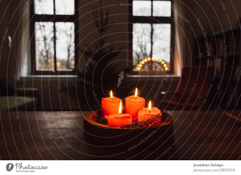 advent wreath with burning red candles standing on wooden table in living room with candle arch in window Bright Christianity Christmas Christmas & Advent