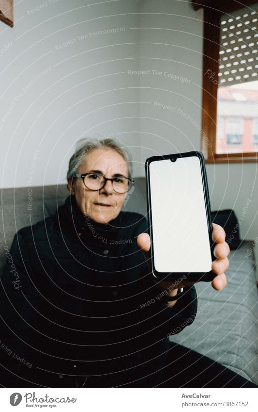Old woman showing a mobile phone with a white screen with copy space person elderly grandmother copyspace mature senior happy older retired retirement call lady