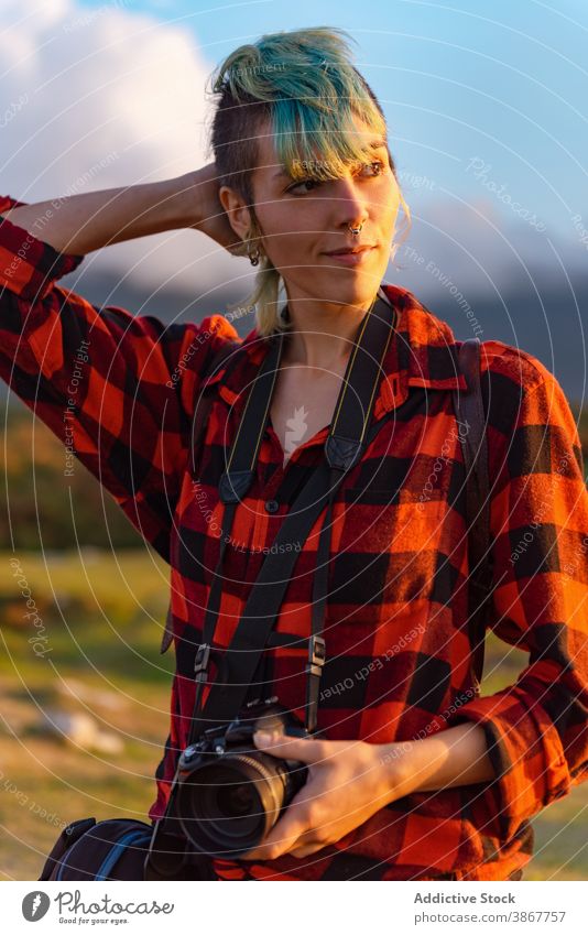 Photographer on hill at sunset travel photographer woman traveler photo camera explore adventure androgynous female alternative gender professional nature area