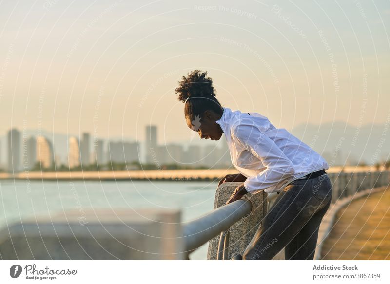 Cheerful black woman having fun on embankment cheerful happy urban laugh enjoy positive young african american ethnic female student seafront lifestyle modern