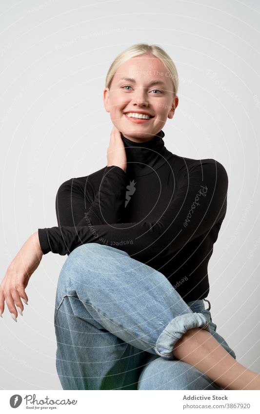Delighted woman laughing in studio casual style natural beauty female cheerful positive delight glad happy young lady legs crossed carefree content enjoy