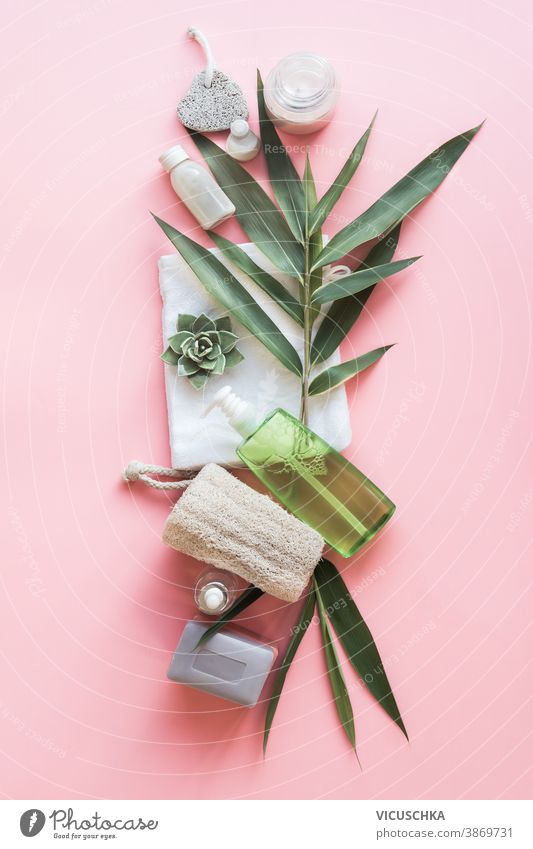 Eco friendly beauty with green bamboo leaves. Skin care bathroom accessories, natural sisal brush, wooden comb, soap, reusable make up removal pads. Zero waste. Top view. Natural and pastel col