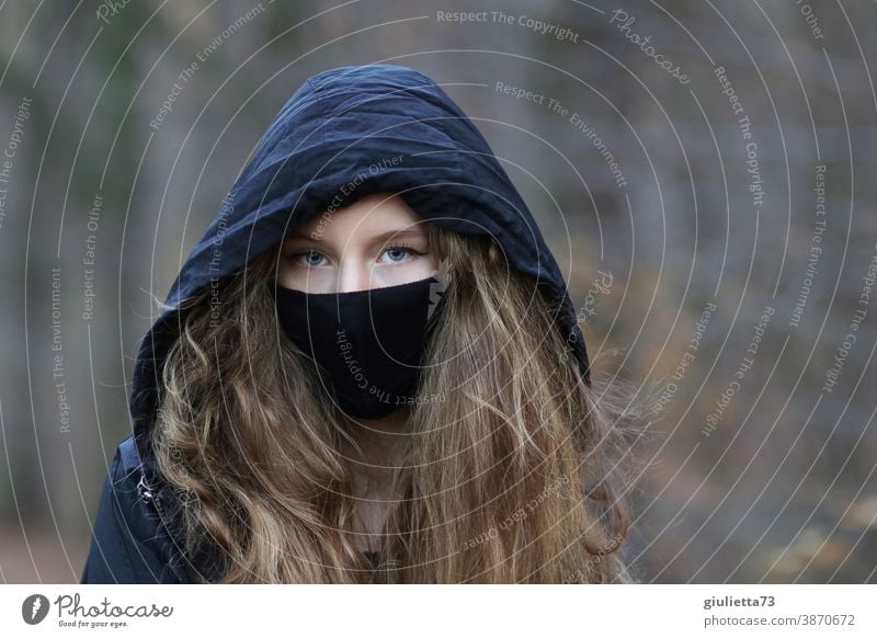 Portrait of a teenage girl with hood and mouth-nose cover, mask I corona thoughts portrait Day Exterior shot Colour photo Puberty Emotions Long-haired