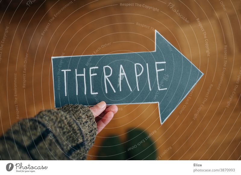 A person holds an arrow with the word therapy. Concept Psychotherapy for mental illness, such as depression, anxiety disorders and addiction problems. Therapy