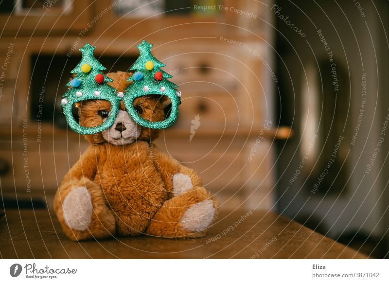 A teddy bear with Christmas tree glasses. Concept Christmas with children. Teddy bear cuddly toy Infancy Christmassy Cap Christmas & Advent Bear material