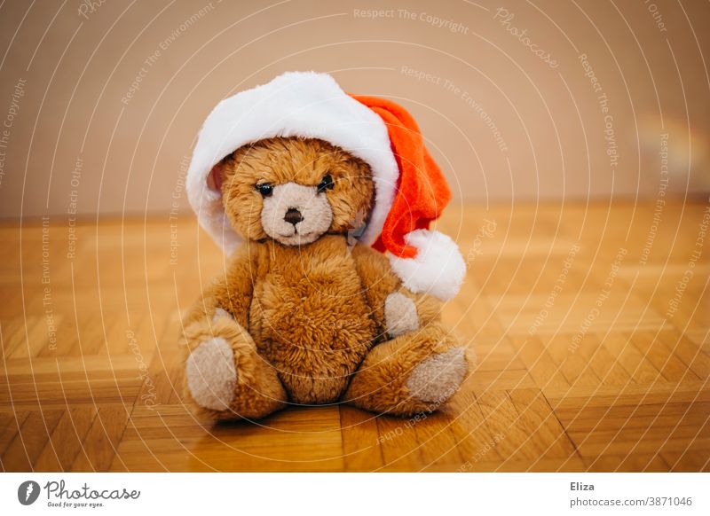 A teddy bear in a Santa hat. Concept Christmas with children. Teddy bear cuddly toy Infancy Santa Claus hat Christmassy Cap Santa's cap Christmas hat