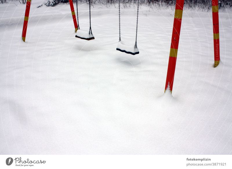 empty playground with two swings in the snow snowed over snowy Snow Winter White Playground Winter sports childcare Swing Snow layer tracks in the snow Lonely