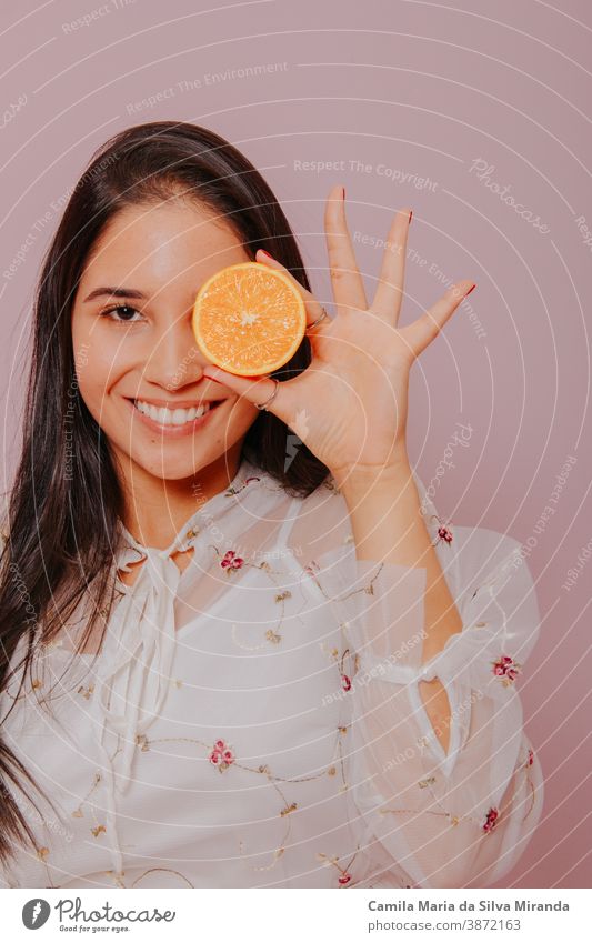 Model holding an orange. Studio shot with pink background. beautiful beauty care citrus closeup cosmetics face fashion fresh fruit girl glamour hair hairstyle