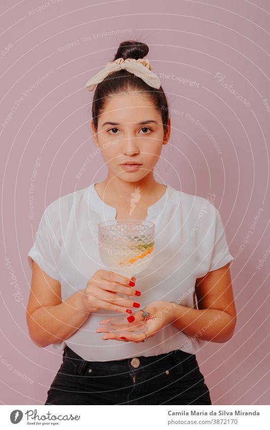 Beautiful female bartender is holding a shot glass with alcohol drink, looking at camera. alcohol - drink background cocktail drinking glass lifestyles