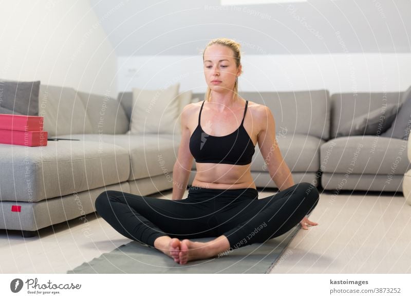 Beautiful blonde woman doing home workout indoors. Woman practice