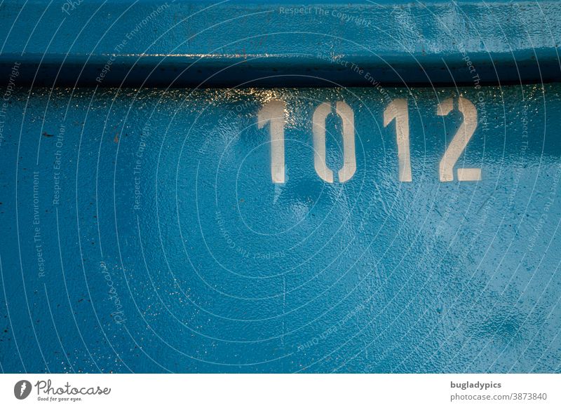 White number 1012 on blue metal background figures Digits and numbers Characters Signs and labeling Blue Container Numbers Metal Lettering Screen print