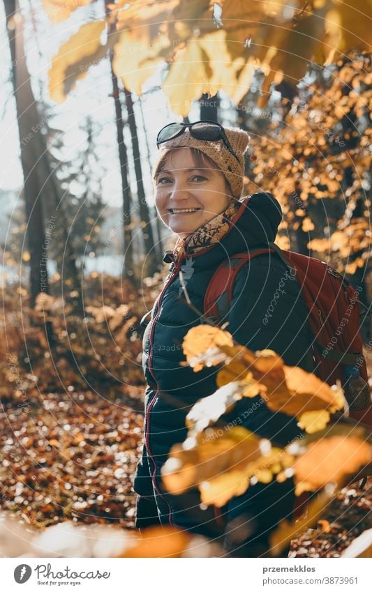 Woman with backpack wandering in a forest on autumn sunny day active activity adventure backpacker destination enjoy exploration explore fall female hike hiker