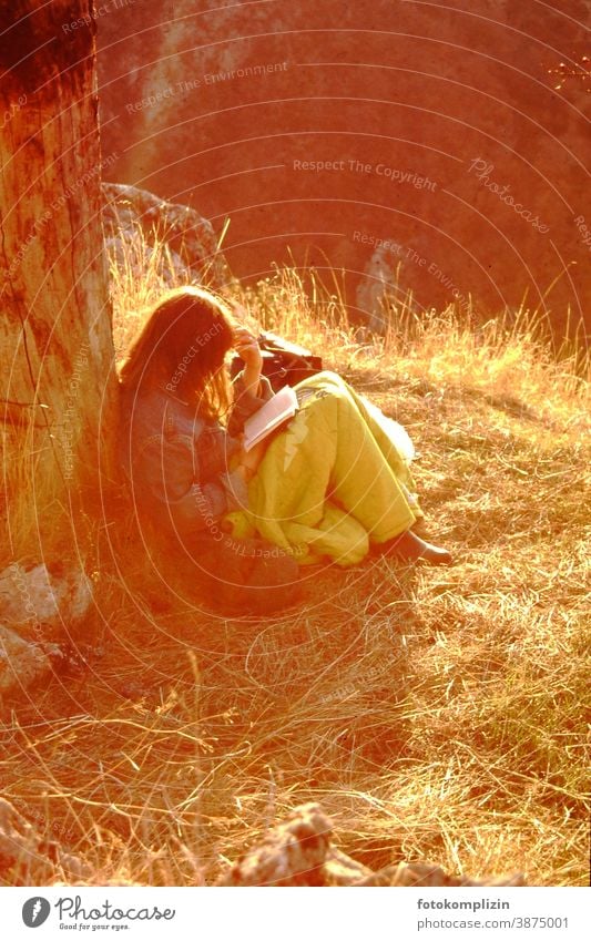 junge Frau, im Sonnenlicht an einen Stamm gelehnt, liest versunken in einem Buch Lesepause lesen Natur Feminine chill Break recover Lonely tranquillity