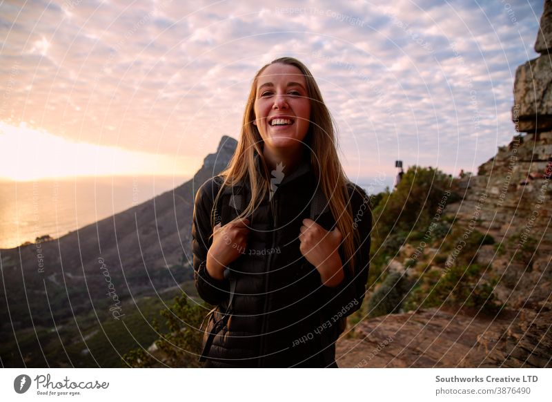 Portrait of happy young woman hiking in the mountains stock photo