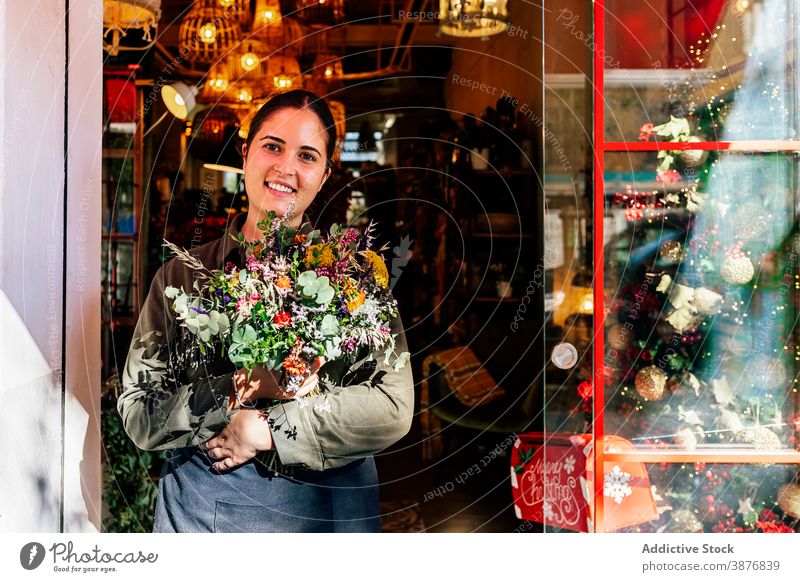 Woman with flower bouquet standing outside shop woman holiday window christmas store festive illumination xmas florist bloom street city celebration ornaments