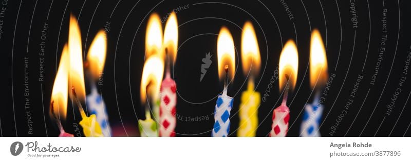 Many burning colourful birthday candles, black background with copy room Flame Fire cauterizing Black Birthday Party fun Anniversary Age shoulder stand