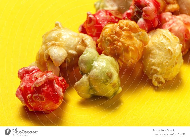 Sweet popcorn on yellow background scatter colorful sweet treat delicious snack multicolored bright crispy heap food pile yummy nutrition appetizing gourmet