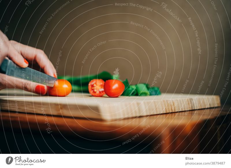 Women's hands cut tomatoes on a cutting board. Spring onions Chopping board preparation Eating boil Fresh Woman Kitchen Cooking Knives Food Bamboo Board