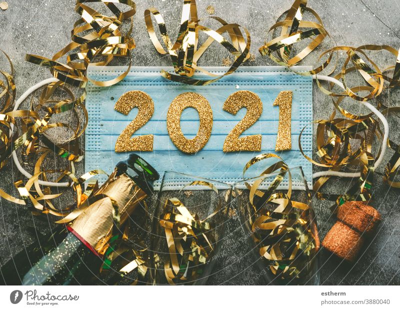 New Years Eve celebration concept background.Medical mask with the numbers 2021 and Champagne bottle with glasses .Covid-19 New Year concept christmas