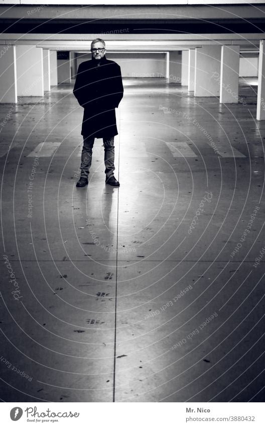 Man In Black Parking garage Light Shadow Artificial light Zebra crossing Gray Concrete columns Dark Coat Reflection Gloomy Abstract Cold Loneliness Cool (slang)