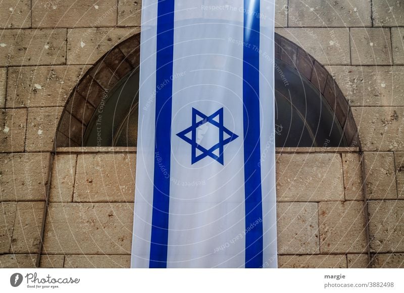 Israel flag, flag with Star of David hung on a building Flag Blue Part of a building Building National Holocaust memorial Religion and faith White Sign Landmark