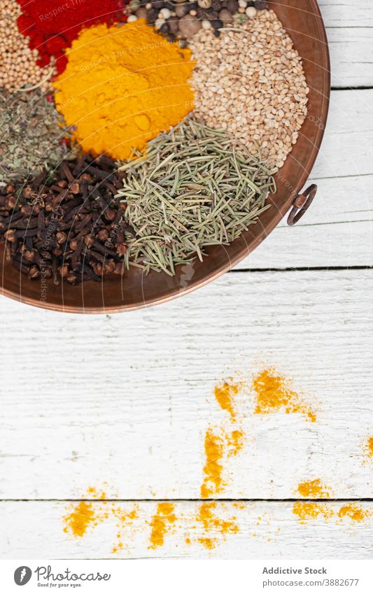 Mix of assorted spices in wooden bowl various mix colorful aromatic condiment seasoning culinary seed powder paprika pepper thyme clove turmeric ingredient dry