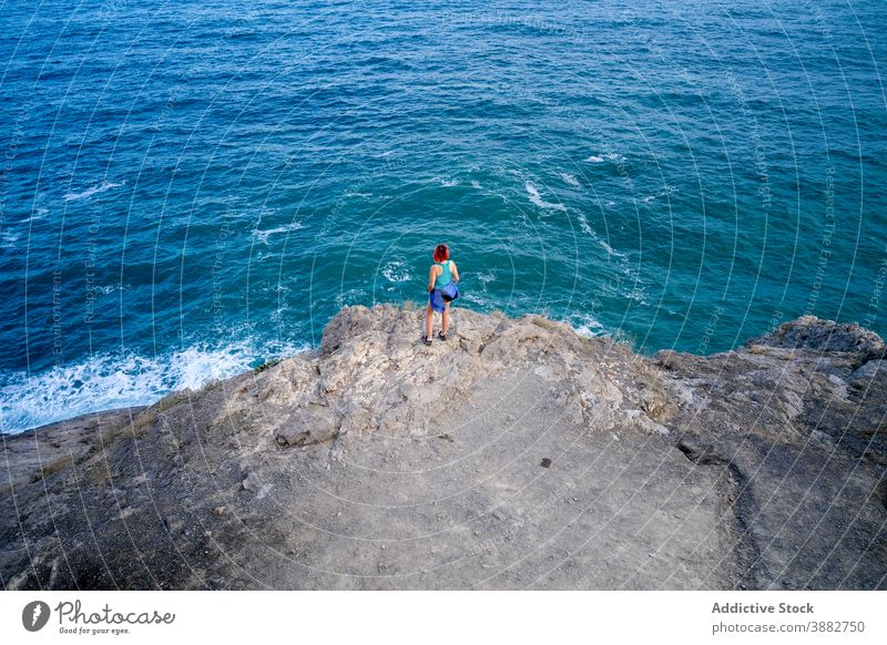 Traveling woman in hill near blue sea turquoise travel observe viewpoint summer vacation adventure admire female tourist rock holiday tourism trip relax water