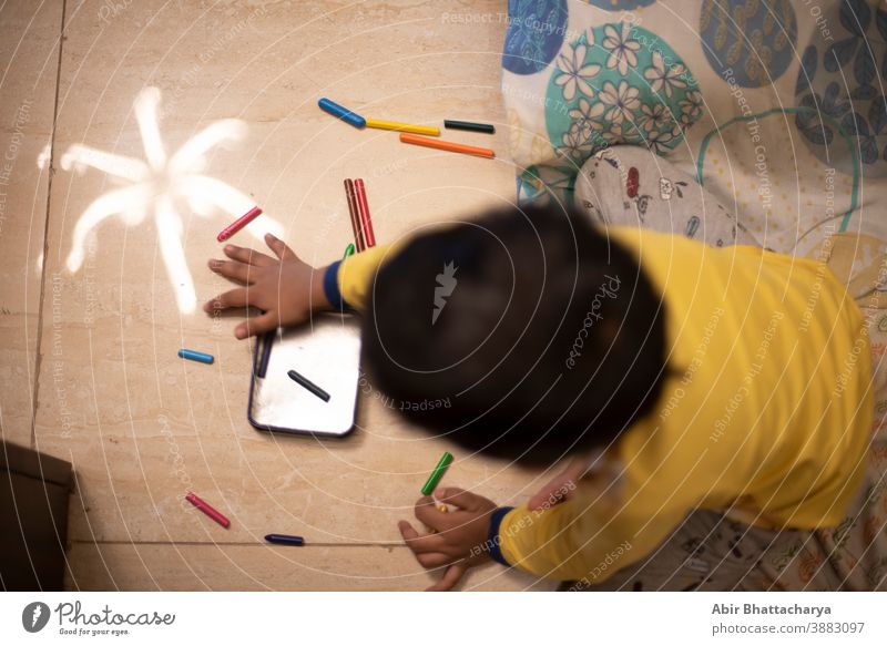 An Indian Bengali baby boy playing with color pencils/sketch pen at  home in a holiday morning. Indian lifestyle asia asian beautiful bengali bengali culture