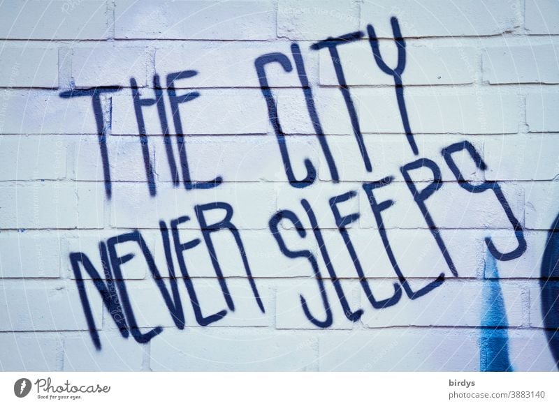 The city never sleeps. Grafitti in English script on a brick wall. Despite Corona City life liveliness Characters Graffiti lockdown Town busyness activity