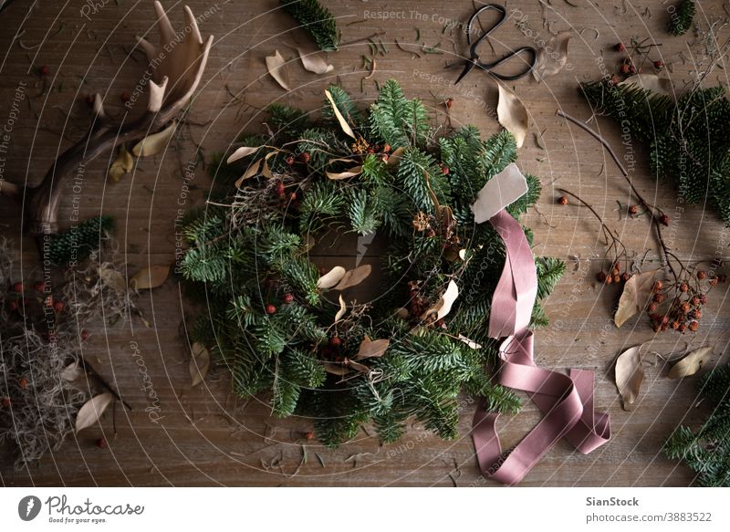 Making Christmas wreath of spruce, step by step. Concept of florist's work before the Christmas holidays. flat lay ribbon hand making wooden table handicraft