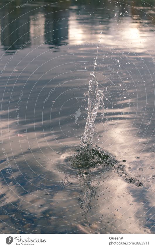 Water syringe with reflections on the water of buildings and sky splash Splash of water Movement Drops of water Fresh Reflection Sunlight Blue Wet Fluid