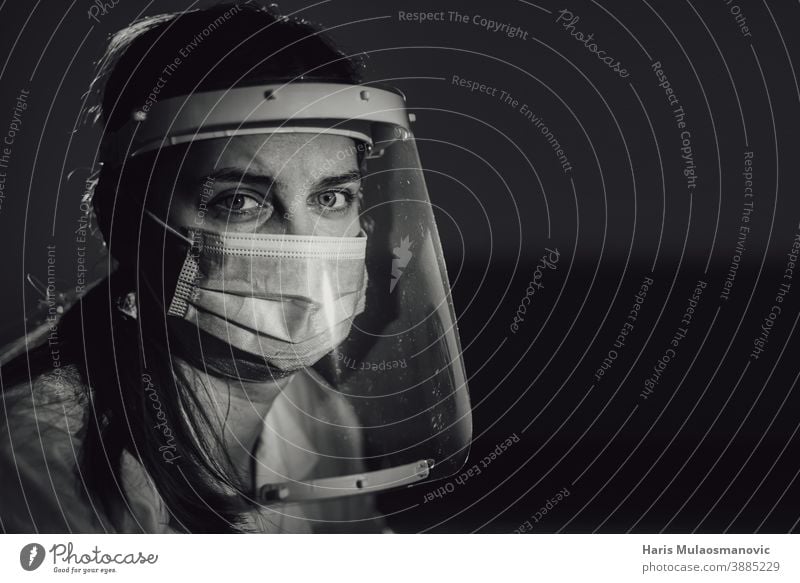 hard working female doctor, heath care worker with face shield and mask in black and white black background brazil corona epidemic corona virus covid-19