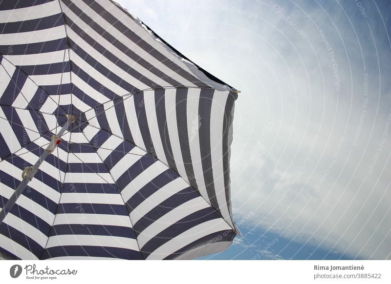 A sun umbrella against clear sky on the beach in the summertime vacation sea travel holidays blue sand relaxation beach umbrella rest recreation